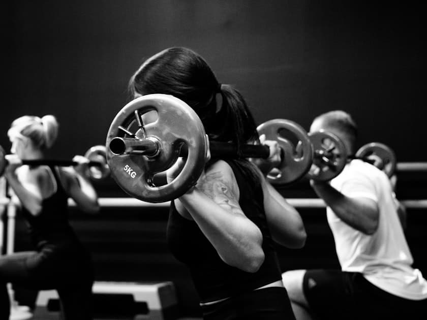 Small group barbell class mid-workout at the gym
