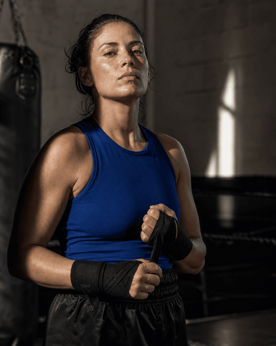 A female boxer wrapping her hands after training